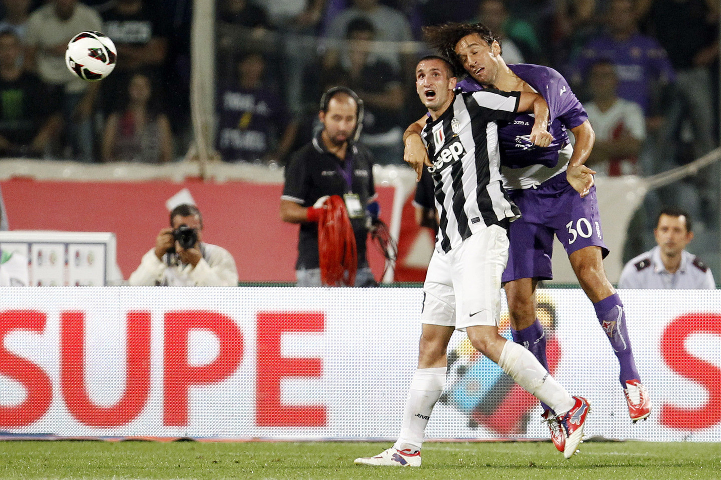 L.Toni kovoja dėl kamuolio su „Juventus“ gynėju Giorgio Chiellini. 2012 metais puolėjas žaidė „Fiorentina“ komandoje.<br>Reuters/Scanpix nuotr.