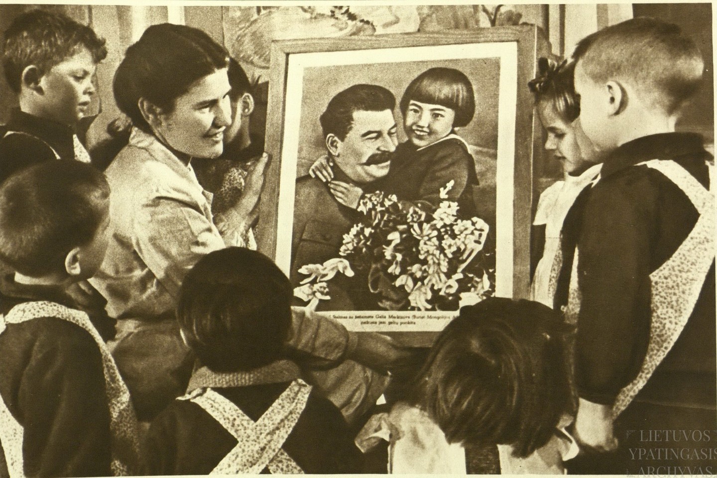 Vaikų darželio auklėtoja pasakoja vaikams apie Sovietų Sąjungos vadovą Josifą Staliną. 1950 m.<br>Lietuvos ypatingojo archyvo nuotr.