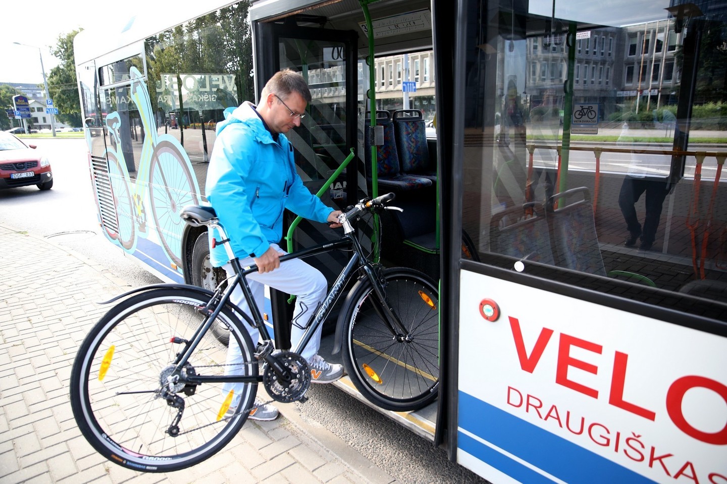 „Vilniaus viešojo transporto“ direktorius Gintaras Maželis stato dviratį į specialią vietą autobuse.<br>Ramūno Danisevičiaus nuotr.