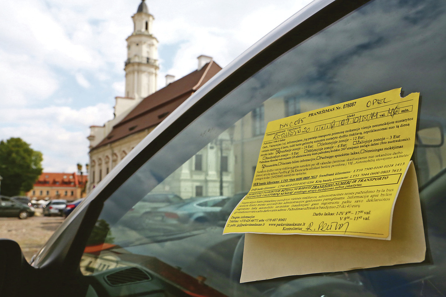 Rotušės aikštėje vis dar netrūksta automobilių, ant kurių langų šviečia geltoni lapeliai, informuojantys apie vietos rinkliavos pažeidimą.