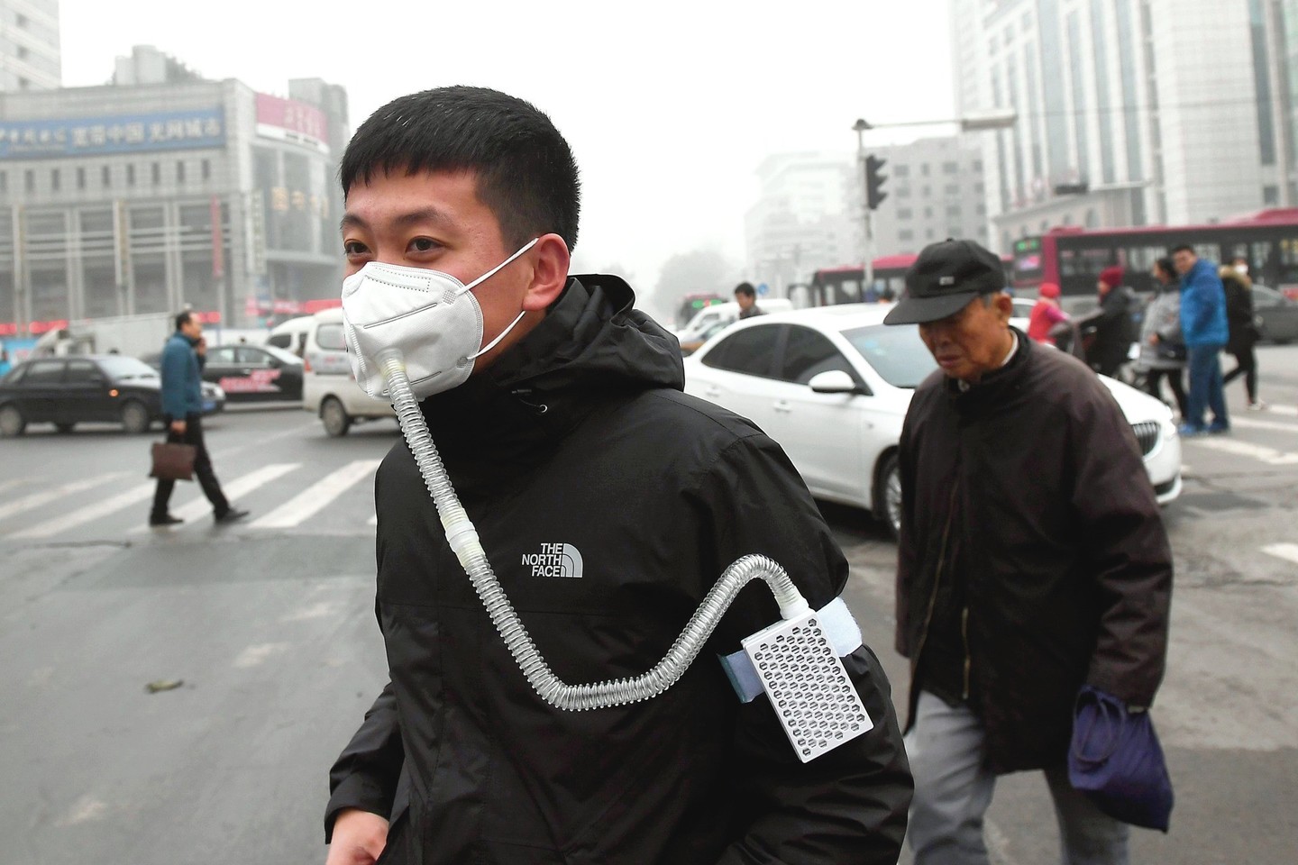 Užterštuose Kinijos miestuose žmonės nešioja respiratorius ir kaukes.<br>AFP/„Scanpix“ nuotr.