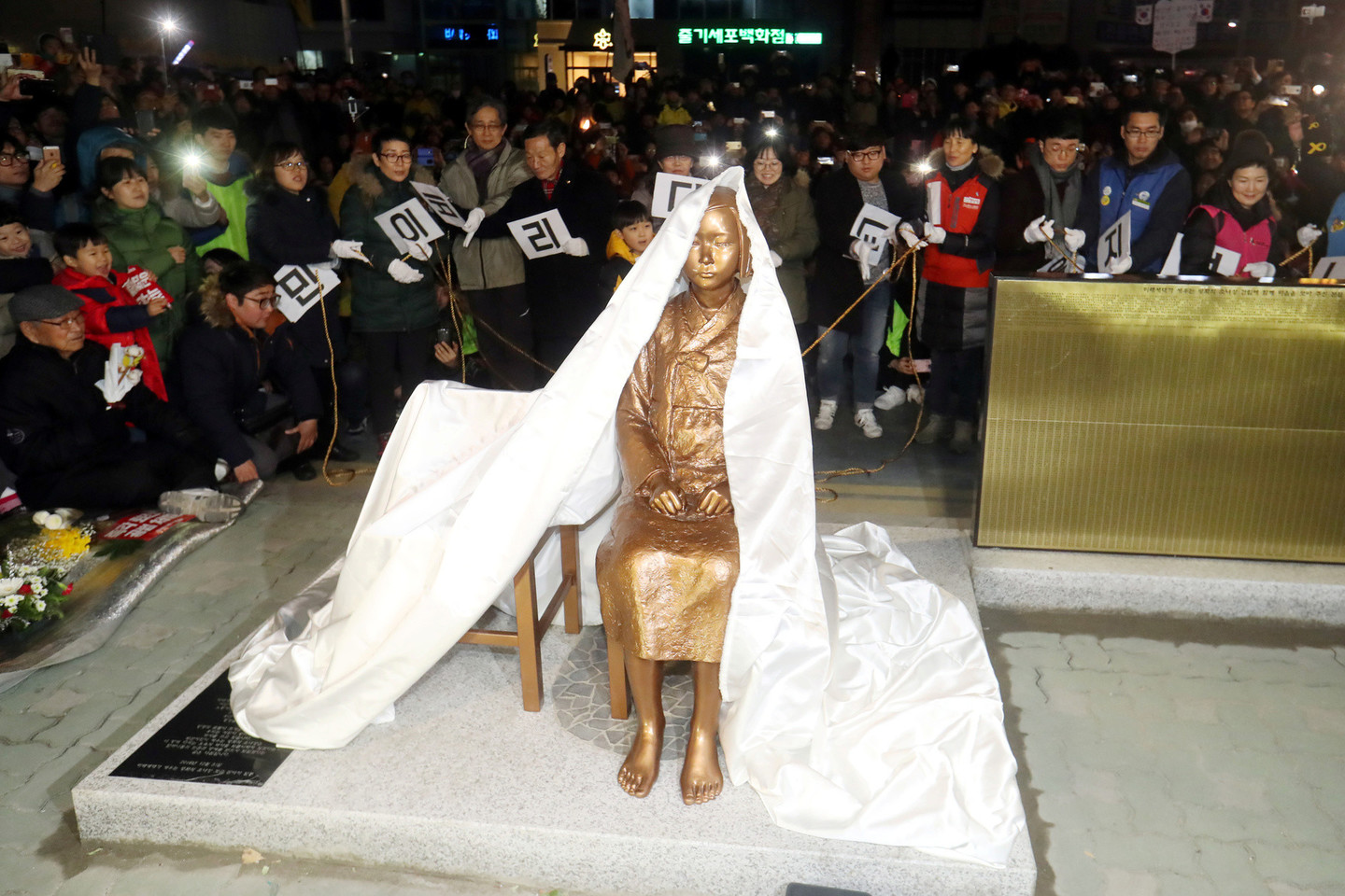 Tokio žingsnio priežastis – Pietų Korėjoje pastatyta statula, vaizduojanti mergaitę, kaip aukos simbolį.