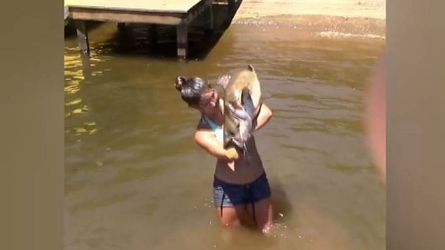 Mergina sužavėjusi tūkstančius: rankomis žvejoja didžiules žuvis