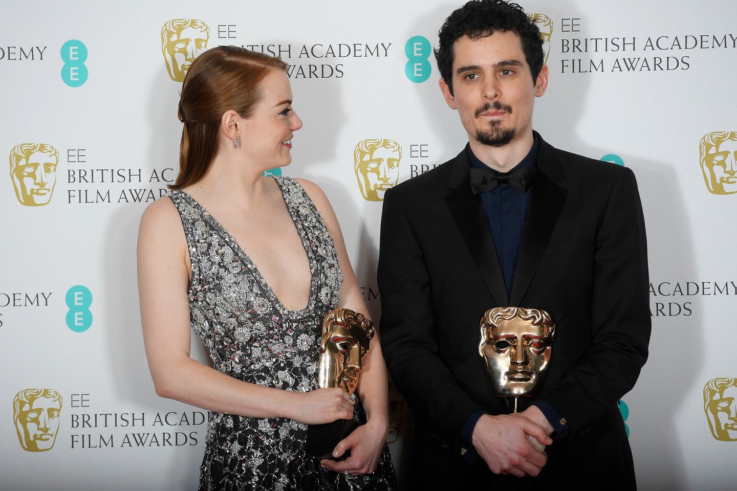 Režisierius D.Chazelle'is ir aktorė E.Stone su BAFTA apdovanojimais.<br>Reuters nuotr.