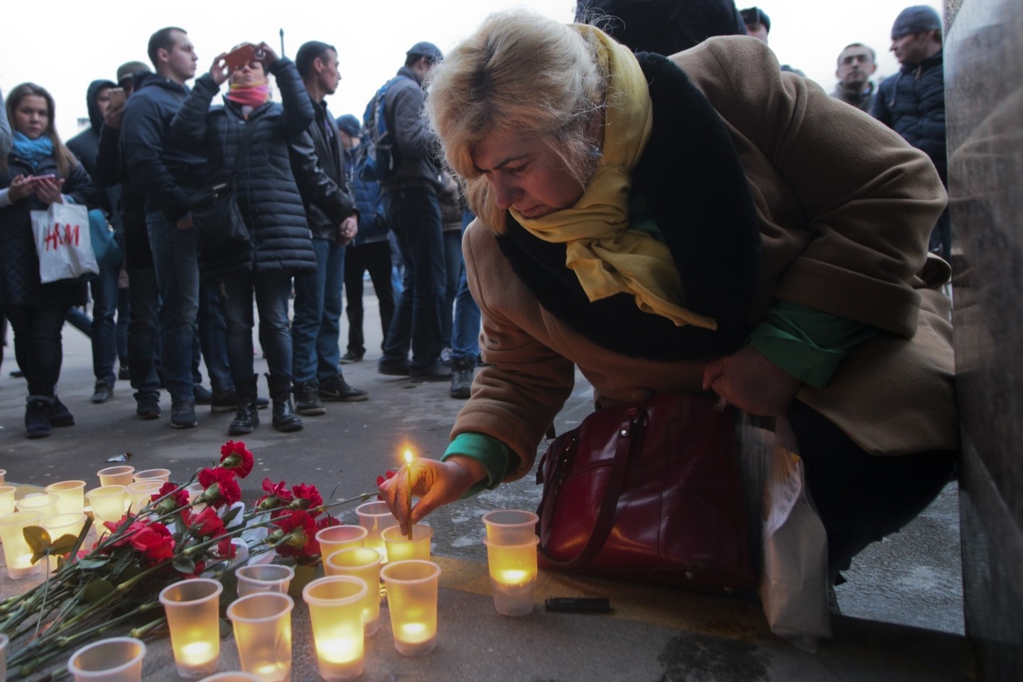 Šalia „Senajos aikštės“ metro stoties žmonės nešė gėles.<br>AP nuotr.