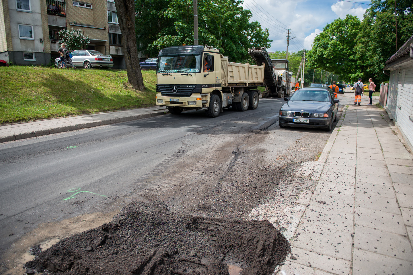  Naują asfaltą Dzūkų gatvėje darbininkai paklojo tiesiog aplink automobilius.<br> J.Stacevičiaus nuotr.