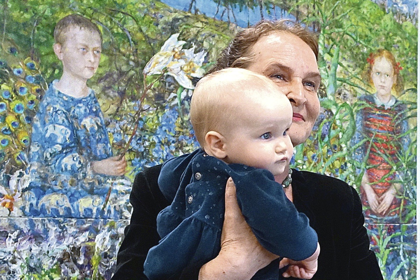 Tapytoja Nomeda Saukienė su anūke Elenyte prie savo paveikslo, kuriame nutapyti abu jos vaikai – Monika ir Mykolas.<br>A.Stausko nuotr.