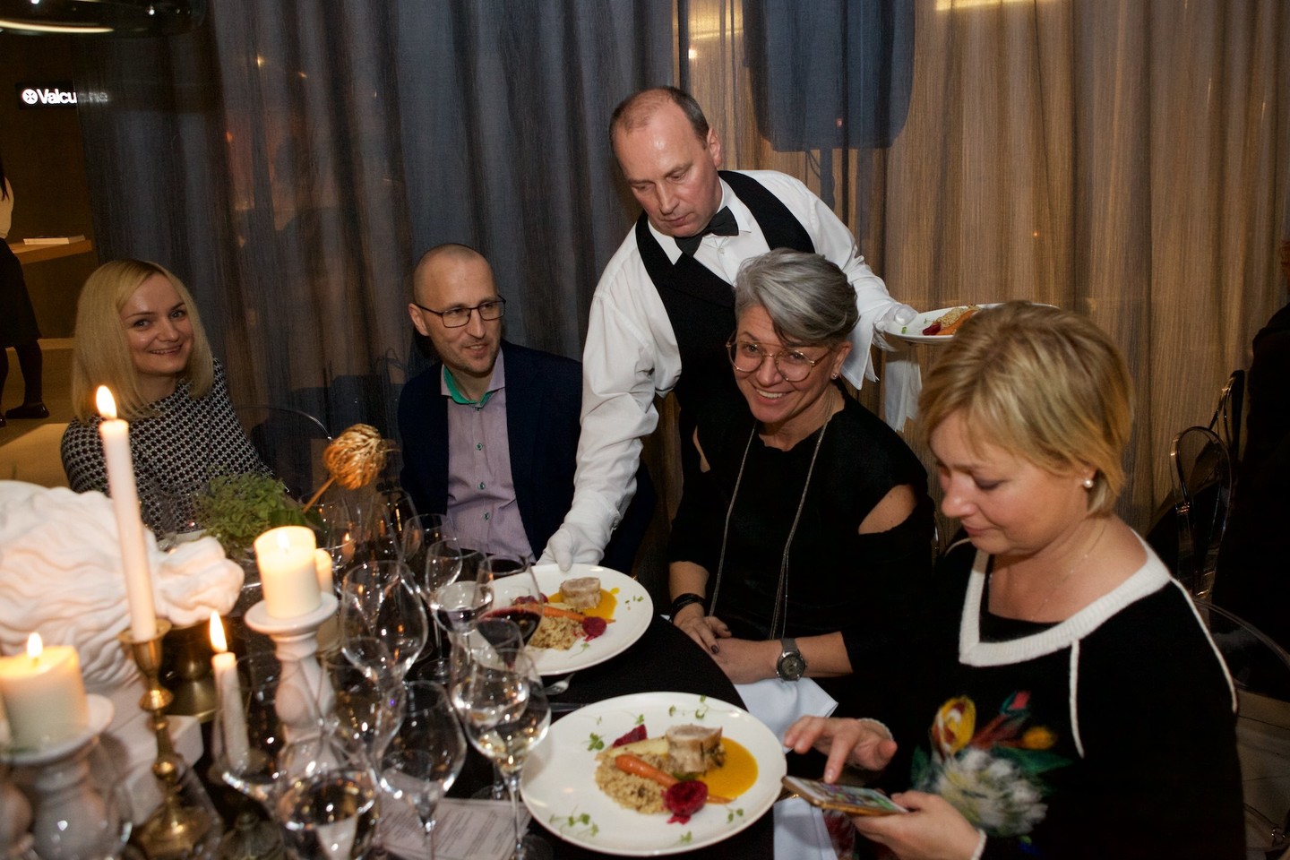 Elegancija ir prabanga alsuojančioje aplinkoje vakaro svečiai buvo kviečiami mėgautis gurmaniškais patiekalais bei prie jų priderintu vynu. <br> Organizatorių nuotr.