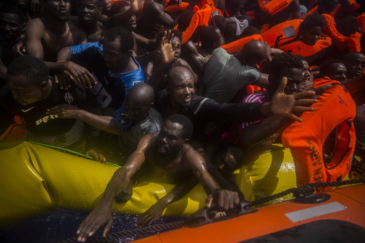  Pabėgėliai iš Afrikos siekia gelbėjimosi liemenių. Liepos 25 d., Viduržemio jūra.<br> AP nuotr.