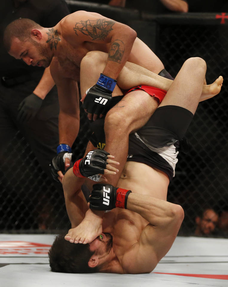  UFC kovos momentas: amerikietis E.Spicely smogia brazilui A.Carlosui. Birželio 3 d., Rios de Žaneiras (Brazilija).<br> AP nuotr.