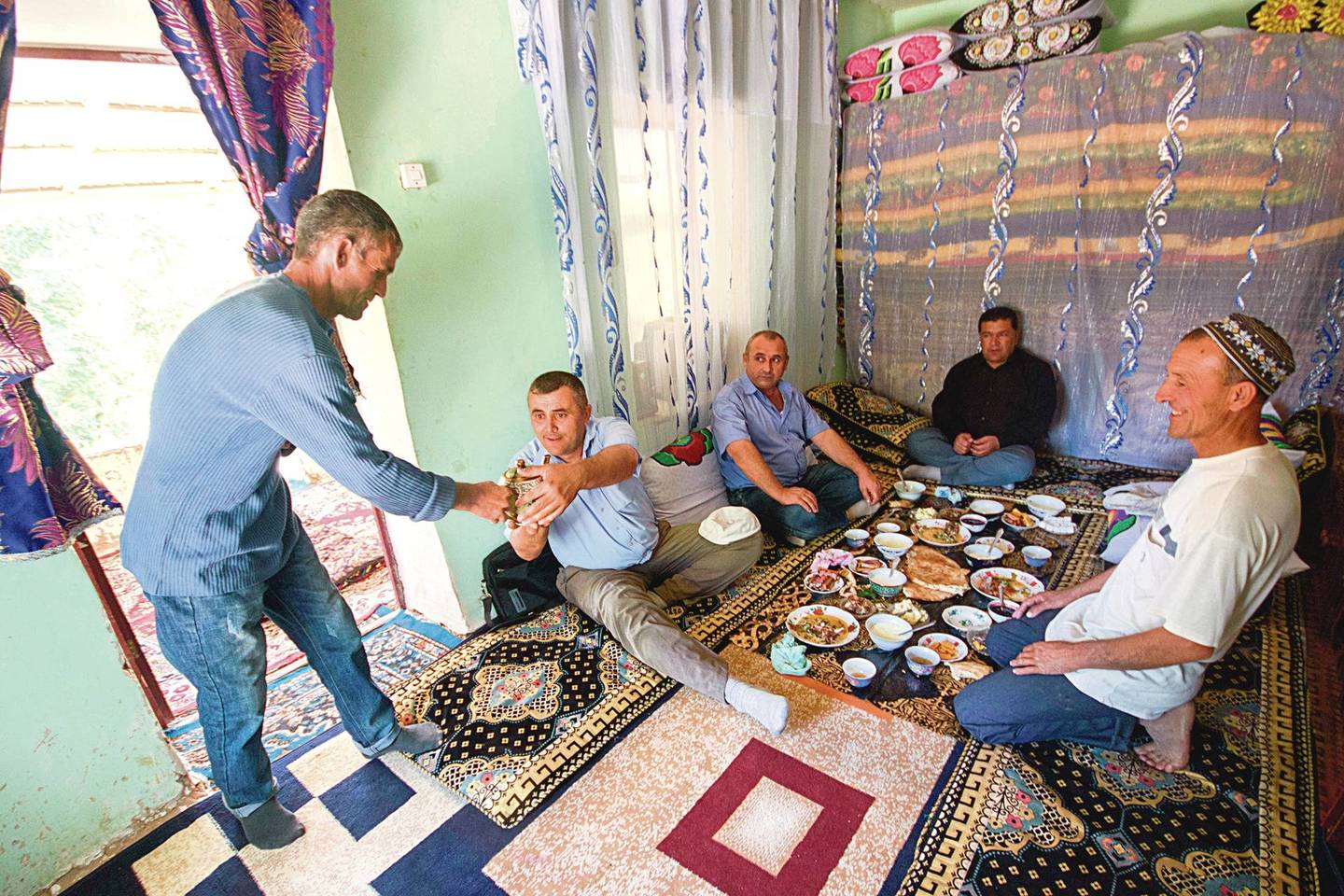 Į tadžikų šeimos namus atvykę svečiai namo nesiruošia, kol jiems nepatiekiama plovo.<br>„ViDA Press“ nuotr.