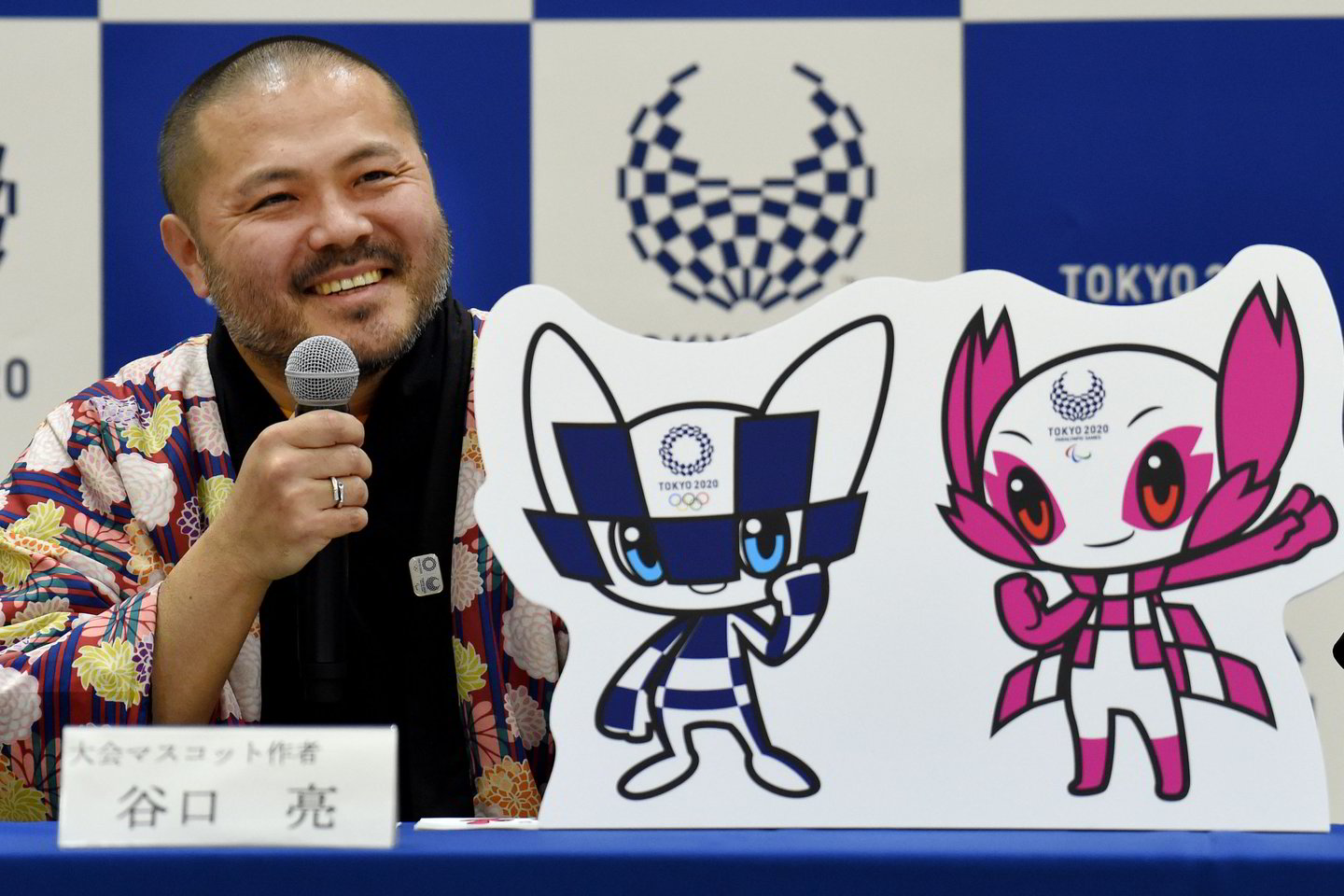 Japonų moksleiviai išrinko ilgai lauktą 2020-ųjų vasaros olimpinių žaidynių talismaną: juo tapo „ypatingų galių“ turintis mėlynais ir baltais langeliais išmargintas futuristinis personažas smailiomis ausimis <br> AP nuotr.