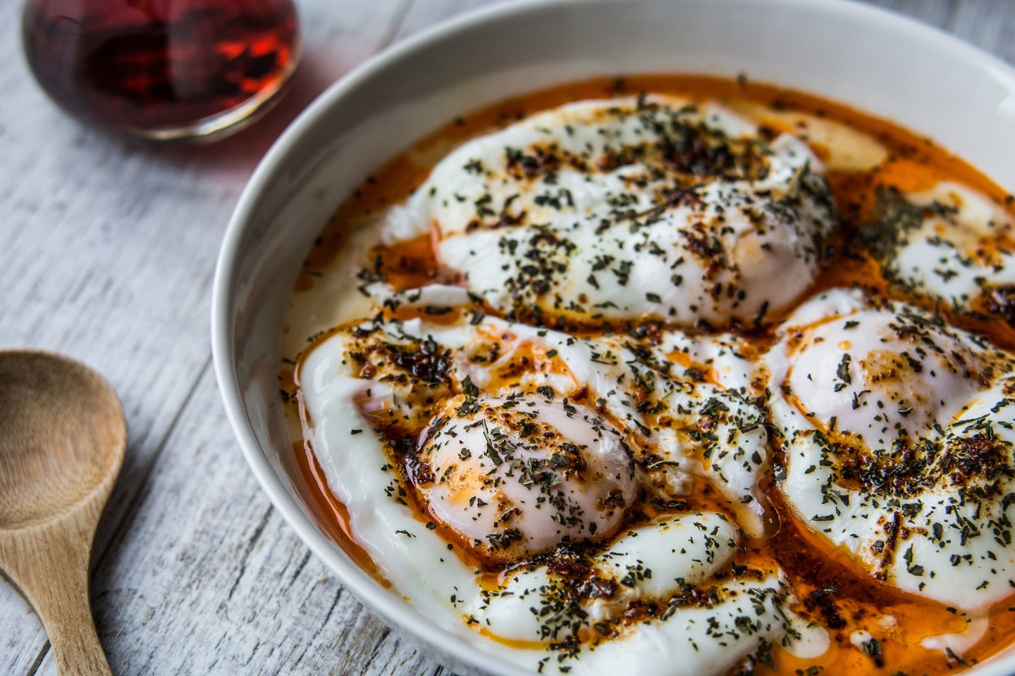 Turkiškai paruošti kiaušiniai – virti be lukšto, patiekti su jogurtu ir aliejumi su aitriosiomis paprikomis.<br> 123rf.com nuotr.