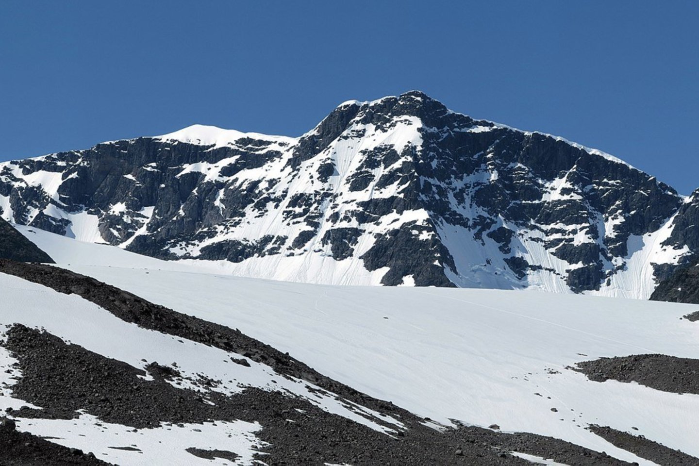 Pietinė Kebnekaisės kalno smailė – pirmą kartą per 140 stebėjimų metų dėl neregėtos kaitros taip aptirpo, kad tapo žemesnė už savo „jaunesniąją seserį“ – šiaurinę smailę.<br> Wikipedia.org nuotr.