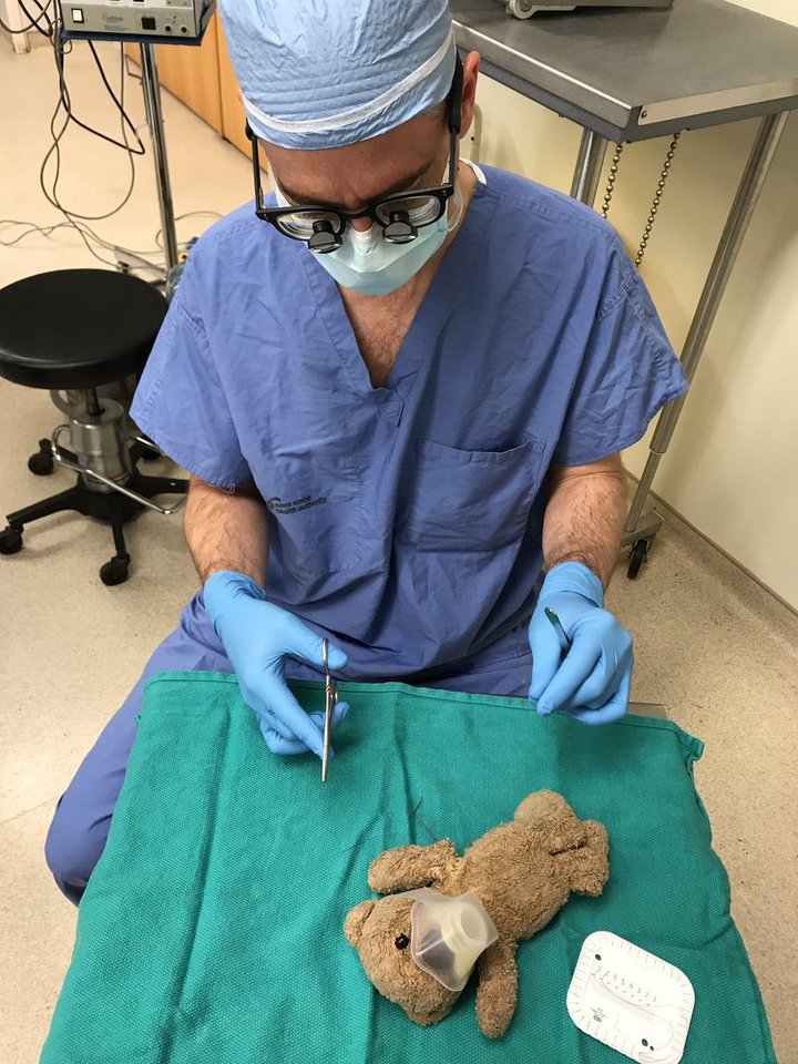 Į meškučio operaciją daktaras Danielis McNeely pažiūrėjo labai atsakingai, net uždėjo žaislui deguonies kaukę. <br> Twitter nuotr. 