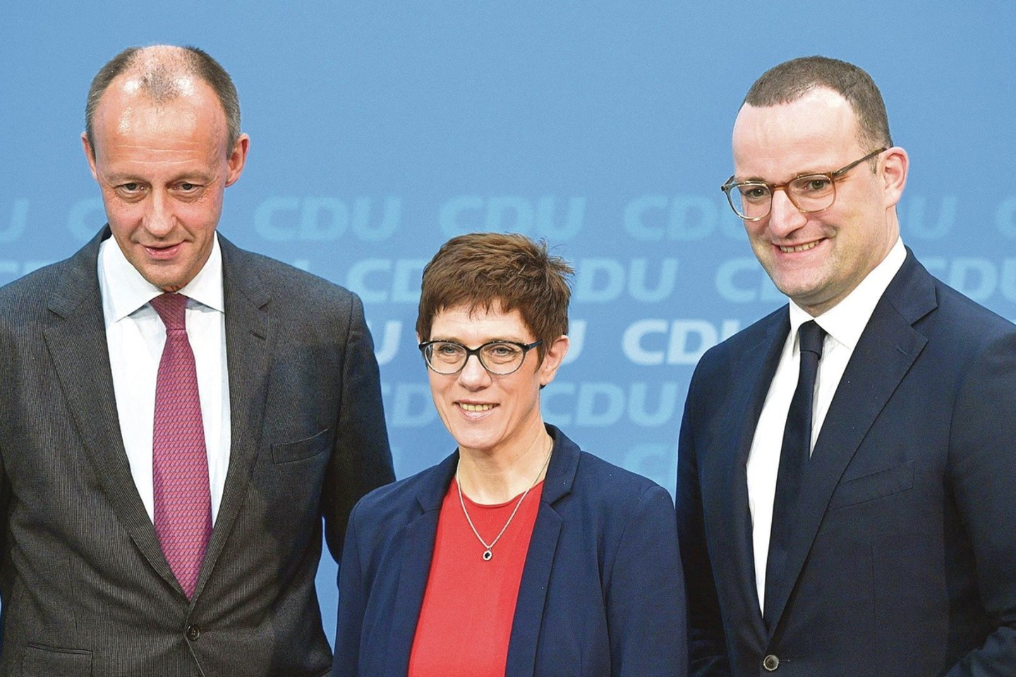 Šiandien į A.Merkel vietą pretenduojantys F.Merzas (nuotr. kairėje) ir J.Spahnas kanclerę kritikuoja. O A.Kramp-Karrenbauer greičiausiai pratęstų jos politiką.<br>AFP/„Scanpix“ nuotr.