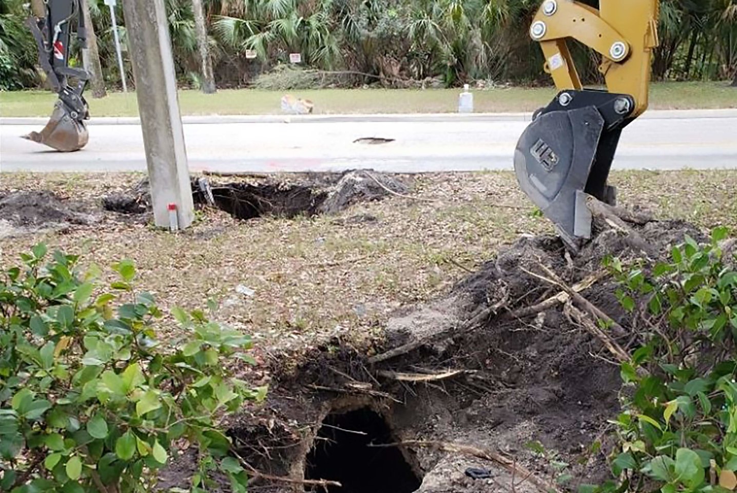 Floridoje kelių darbininkai, šią savaitę iškviesti dėl atsivėrusios įgriuvos, nustebo nustatę, kad jos priežastis buvo įtartinas tunelis, vedantis netoliese esančio banko link. <br> AFP/Scanpix nuotr.