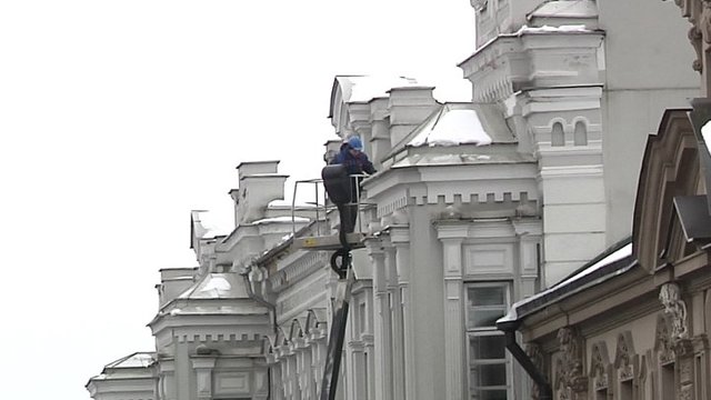 Vilniuje darbininkai pluša be sustojimo – nuo stogų valo sniego sankaupas