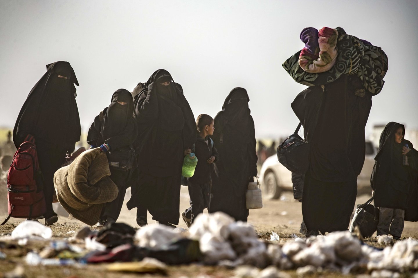  Šimtai sukrėstų moterų ir vaikų pasišiaušusiais plaukais, klupinėdami ėjo per vėjo pustomą dykumą rytinėje Sirijos dalyje, nešdamiesi tai, ką galėjo išsinešti, bėgdami iš paskutinio džihadistų grupuotės „Islamo valstybė“ (IV) teritorijos lopinėlio.<br> AFP/Scanpix nuotr.