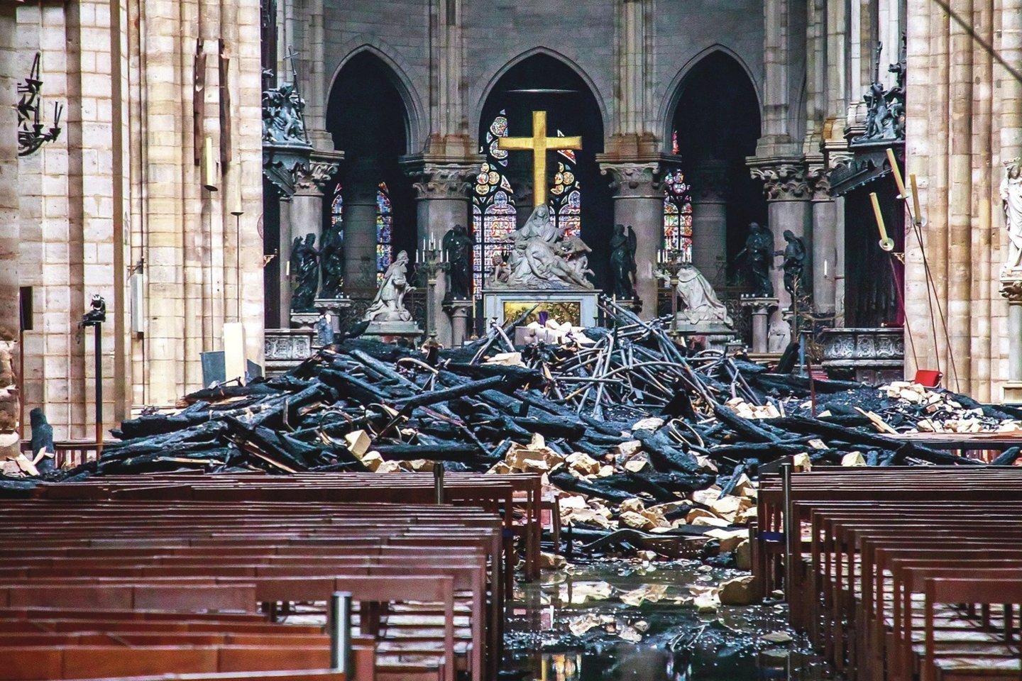 Antradienį buvo galima pažvelgti į katedros vidų – tarp nuodėgulių žibėjo ugnies nesunaikintas kryžius.<br>„Reuters“/„Scanpix“ nuotr.