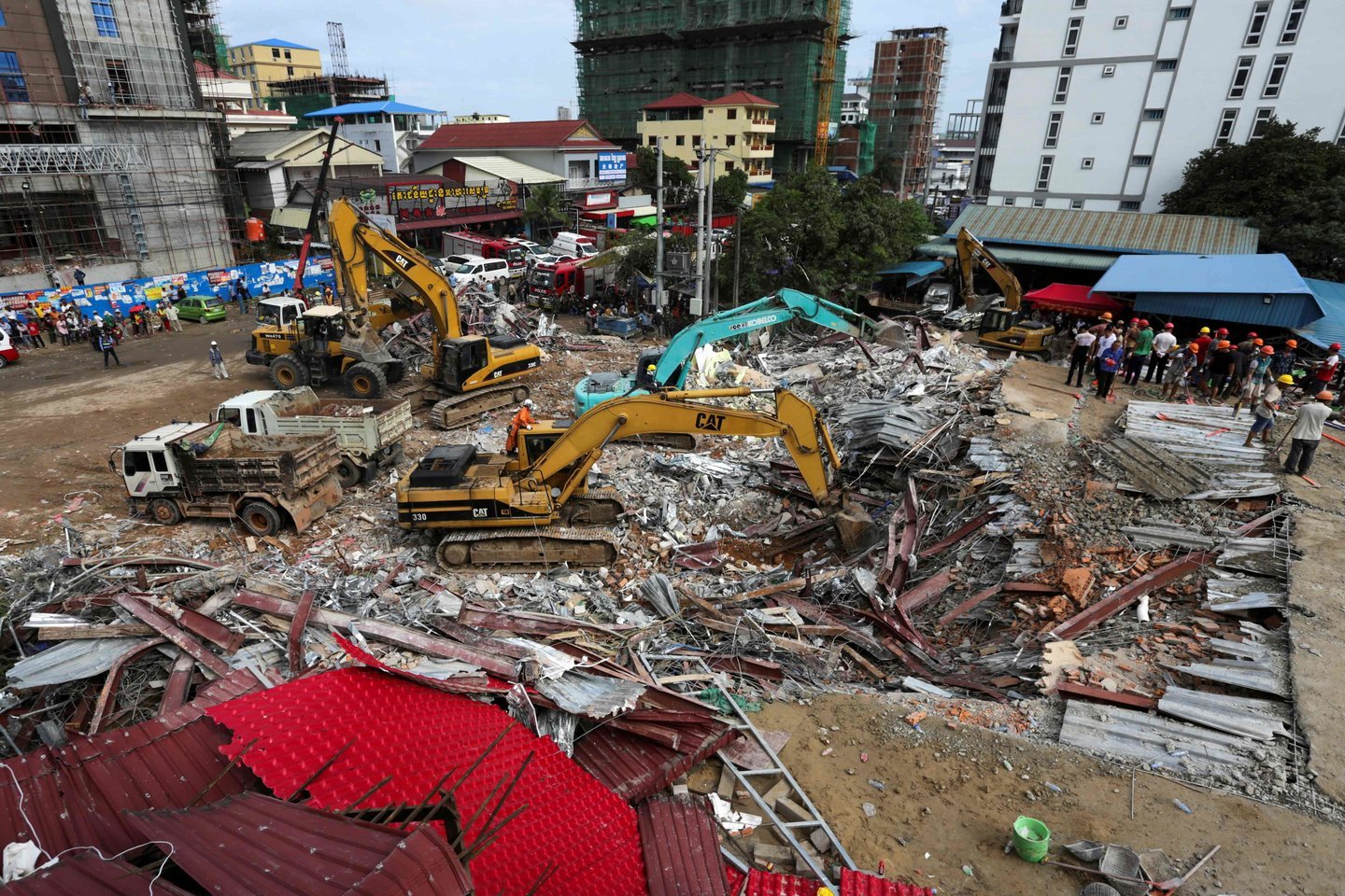  Viename Kambodžos kurorte mažiausiai 17 žmonių žuvo sugriuvus Kinijos įmonei priklausančiam statomam namui, sekmadienį pranešė pareigūnai.<br> AFP/Scanpix nuotr.