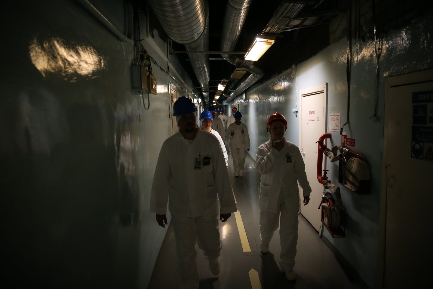 600 metrų koridorius veda į reaktoriaus salę. Nors, atrodytų, koridorius neblogai apšviestas, čia vis dėlto vyrauja prietema. Užtat – pavydėtinai švaru.<br> R. Danisevičiaus nuotr.