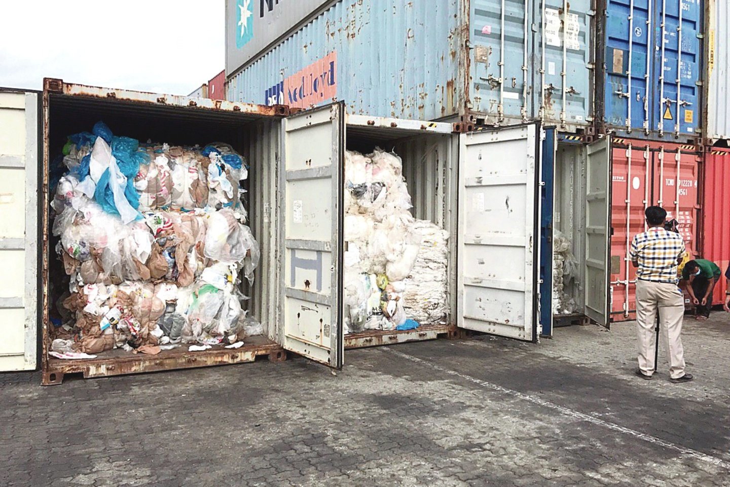 Šimtai šiukšlių konteinerių iš JAV kas mėnesį atkeliauja į Kambodžos pajūrio miestelį Sihanukvilį. Skurdžios šalys nesusitvarko ir su savo gyventojų atliekomis, o dar importuoja jas iš užsienio.<br>Zumapress/Scanpix nuotr.