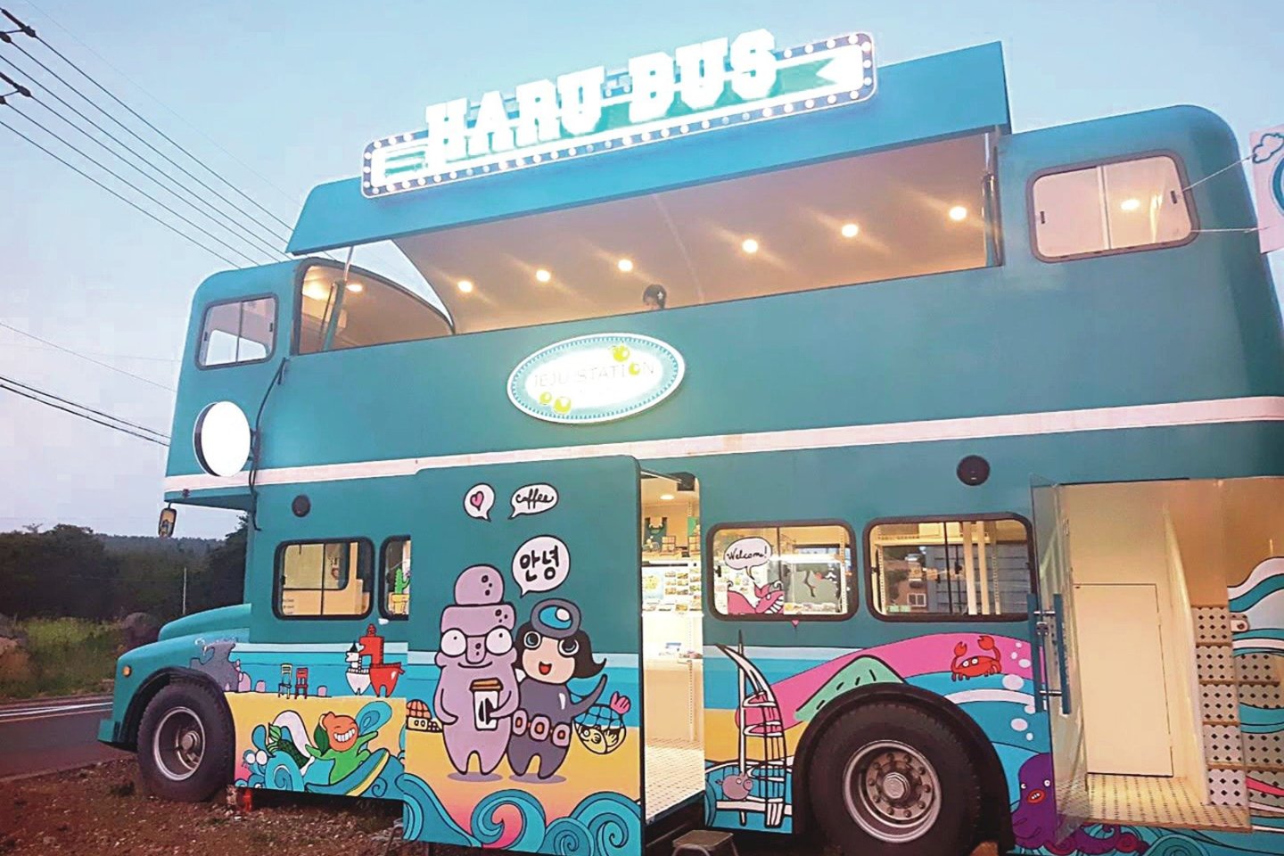 Menininkų parduotuvė atrodo kaip dviaukštis Londono autobusas, tik yra mėlynos spalvos ir dekoruotas garsiausių salos turistinių vietų iliustracijomis bei Pietų Korėjoje pritapusios A.Latinytės sukurtais veikėjais.<br>Nuotr. iš asmeninio albumo