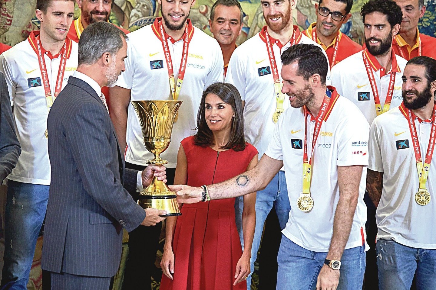 Ispanijos vyrų krepšinio rinktinės kapitonas R.Fernandezas (dešinėje) per priėmimą rūmuose perdavė čempionų taurę karaliui Felipe VI ir karalienei Letiziai.<br>„Scanpix“ nuotr.