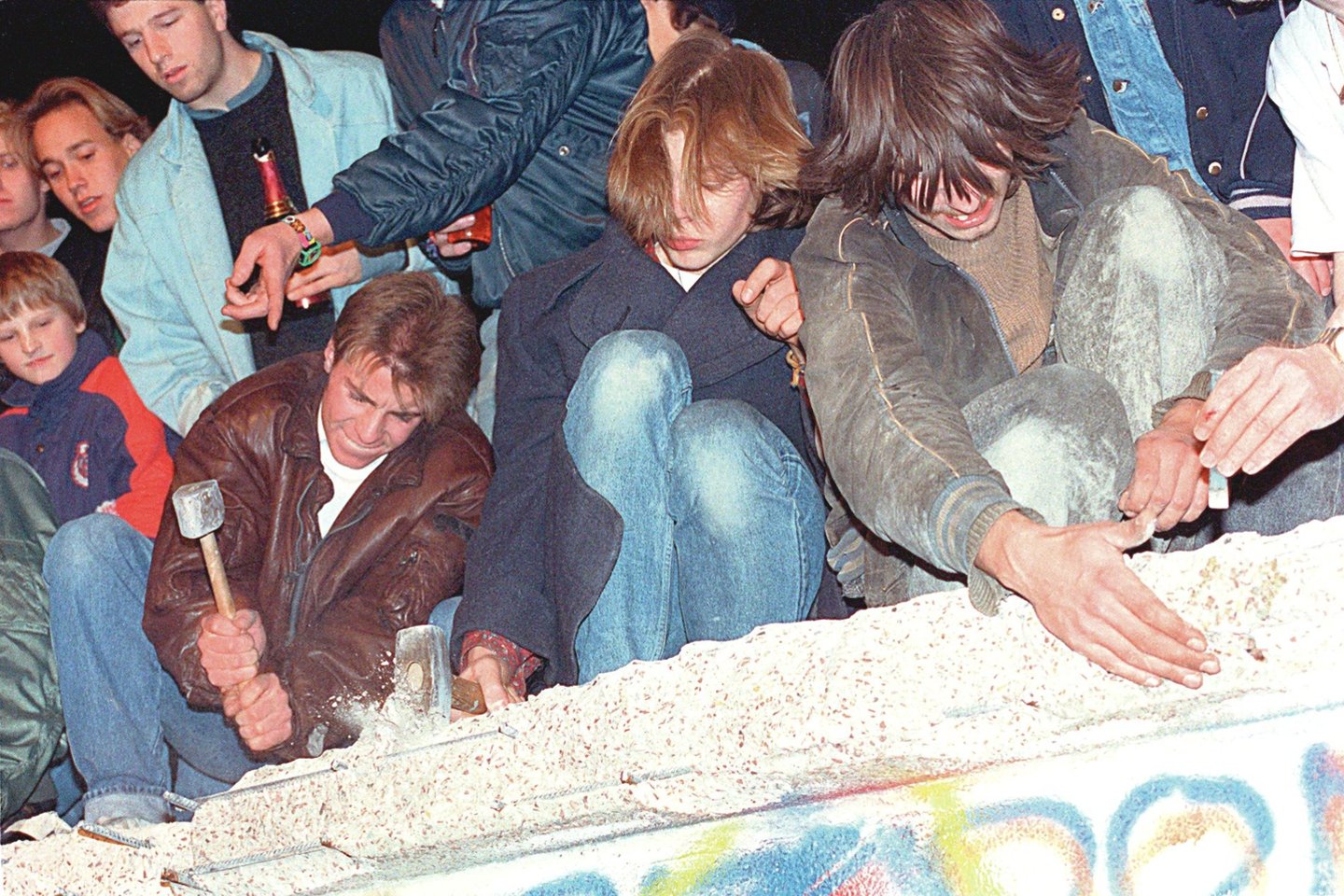 Sienos, kuri skyrė Berlyną, dalijo šeimas, kėlė skausmą, griūtis tapo pokyčių kulminacija. Žmonės betono konstrukciją daužė plaktukais, plėšė, draskė rankomis.<br>AFP/„Scanpix“ nuotr.