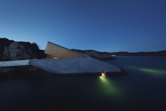 Projektas „Under“, architektai „Snohetta“. Restoranas po vandeniu veikia greta Boliaus kaimelio, Norvegijos Lindesneso regione, šalies pietuose. „Snohetta“ kūrinys iš dalies yra paniręs po vandeniu, todėl čia valgantieji pro didžiulį stiklą gali mėgautis jūros vaizdais.<br>Ivar Kvaal / archdaily.com nuotr.