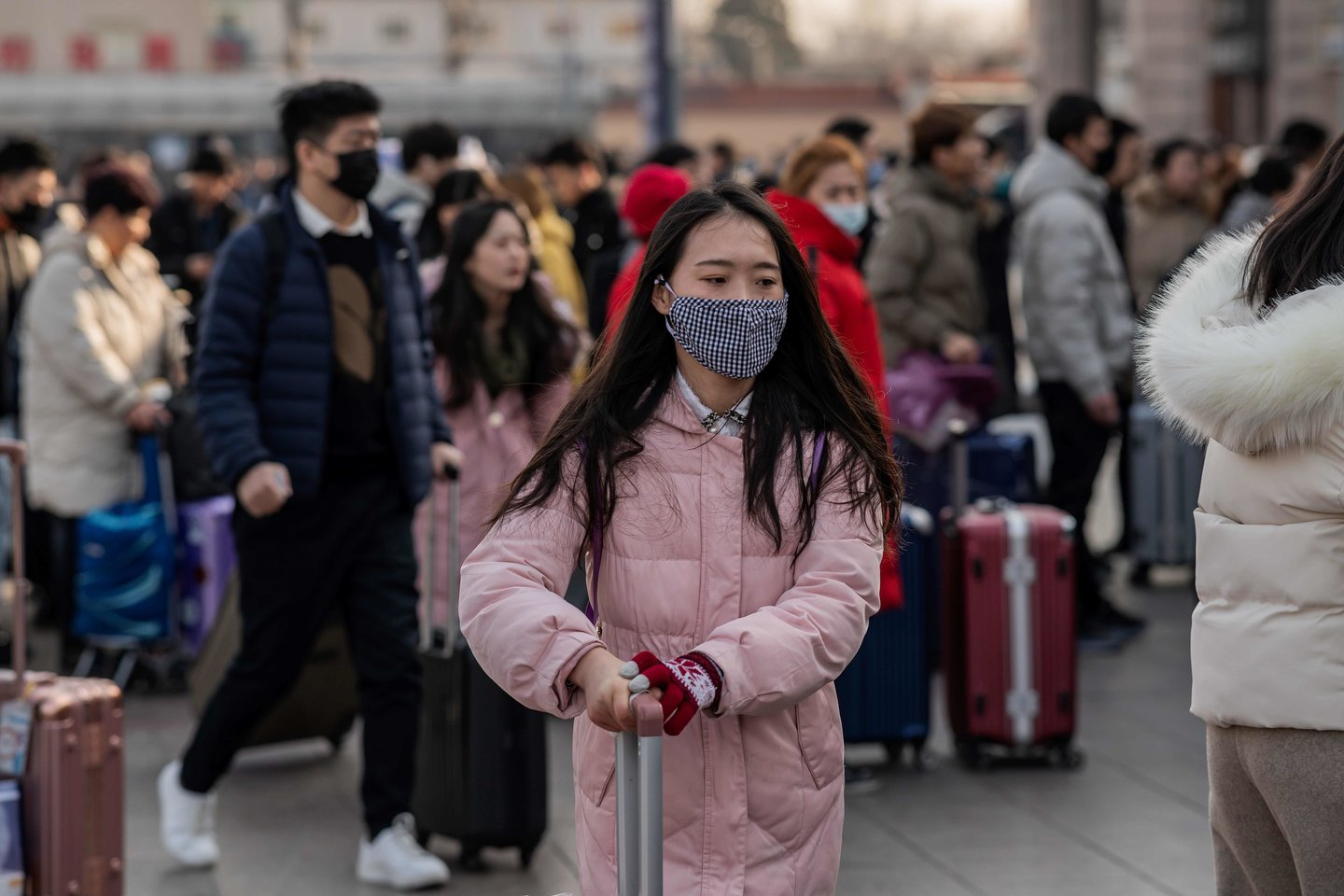 Žmonės dėvi kaukes Kinijos sostinės Pekino traukinių stotyje, vildamiesi apsisaugoti nuo pavojingojo viruso.<br>Scanpix/AFP nuotr.