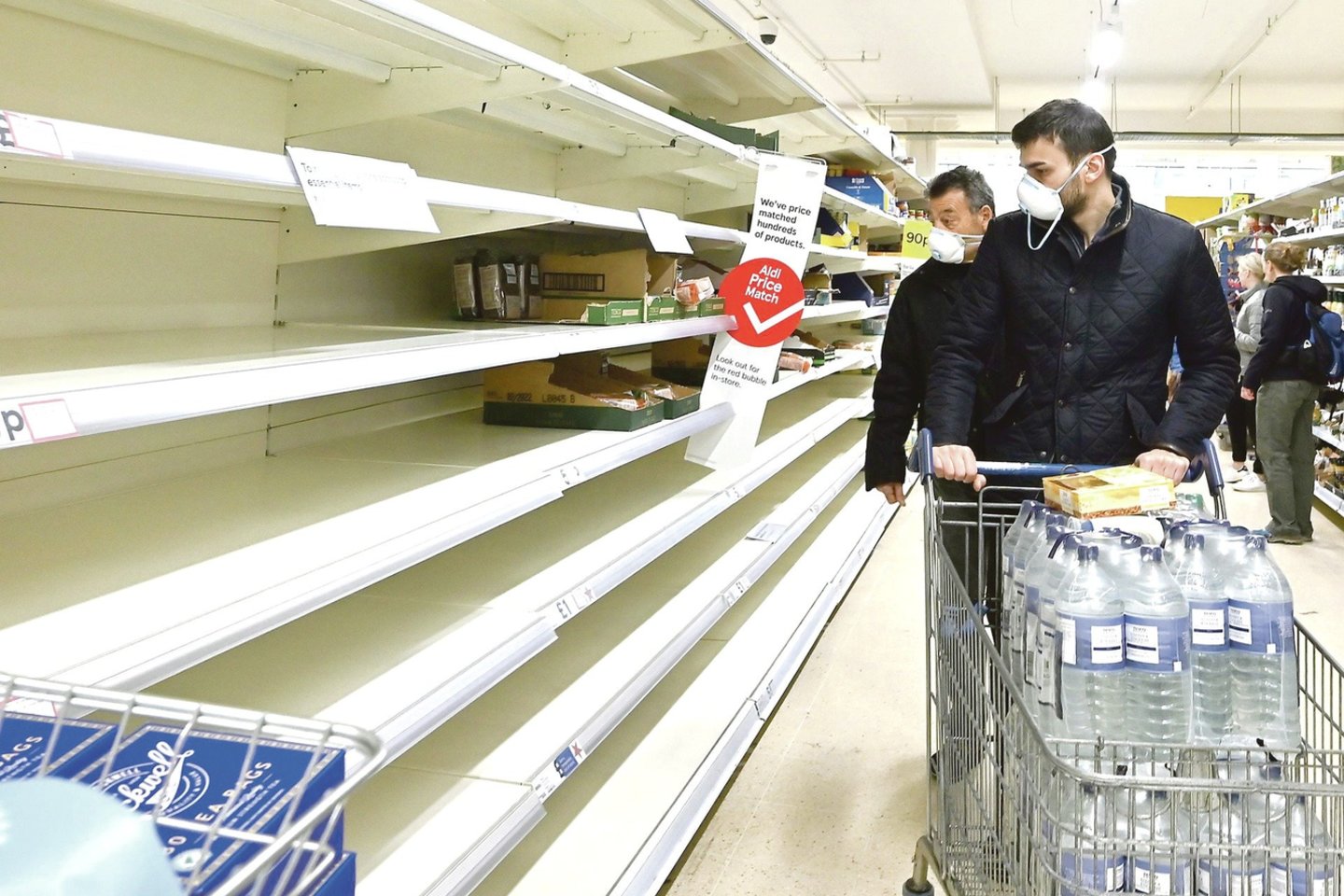 Jungtinėje Karalystėje parduotuvių lentynos faktiškai tuščios. Panikos apimti žmonės perka viską, ką mato.<br>AFP/„Scanpix“ nuotr.