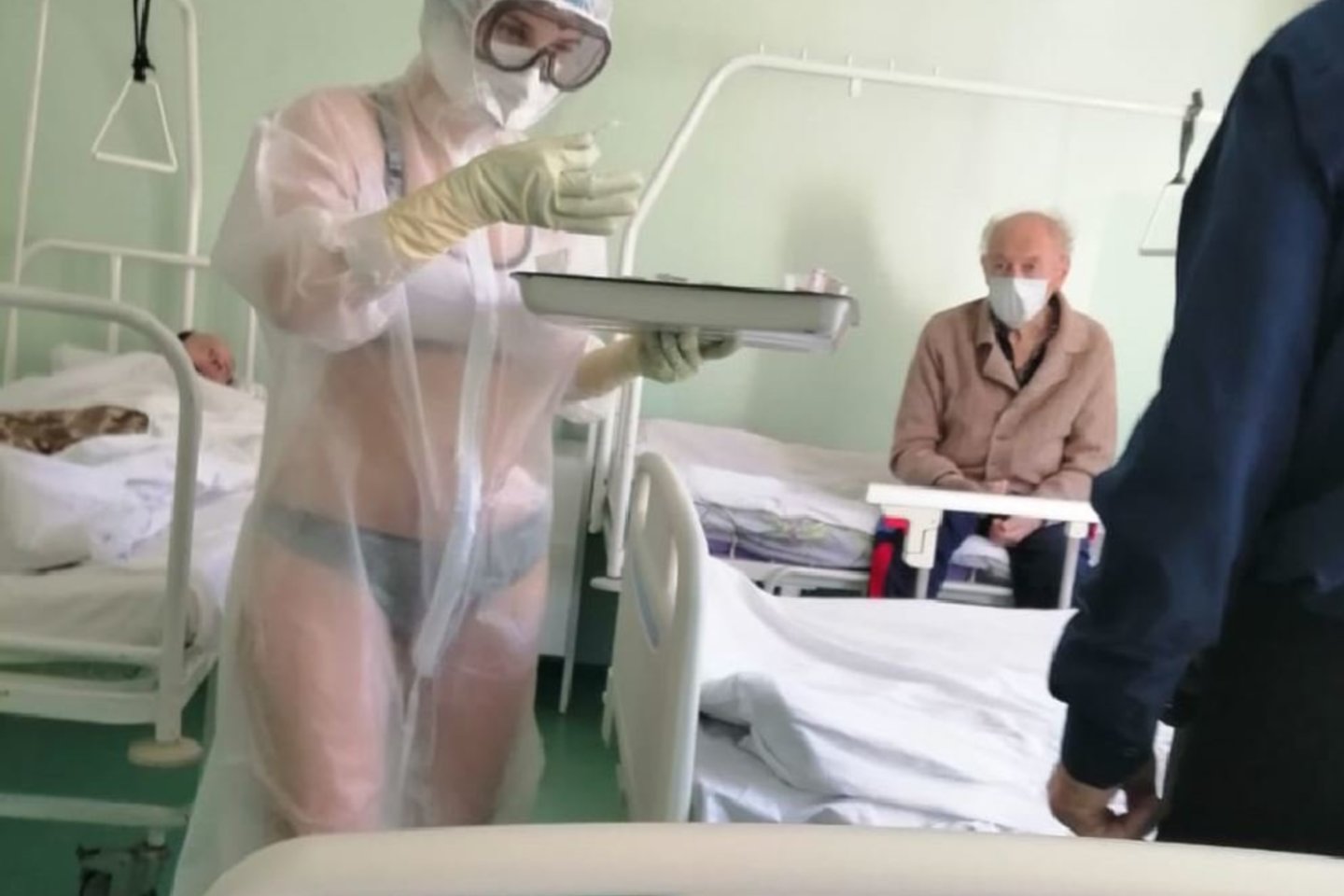 Medicinos seselė iš vienos Tulos ligoninių, nustebino savo apranga. Vienoje iš Rusijos ligoninių besidarbuojanti mergina sulaukė nuobaudų iš ligoninės personalo, nes po apsauginiais rūbais nuo koronaviruso dėvėjo tik apatinius.<br>soc.tinklo „Twitter“ nuotr.