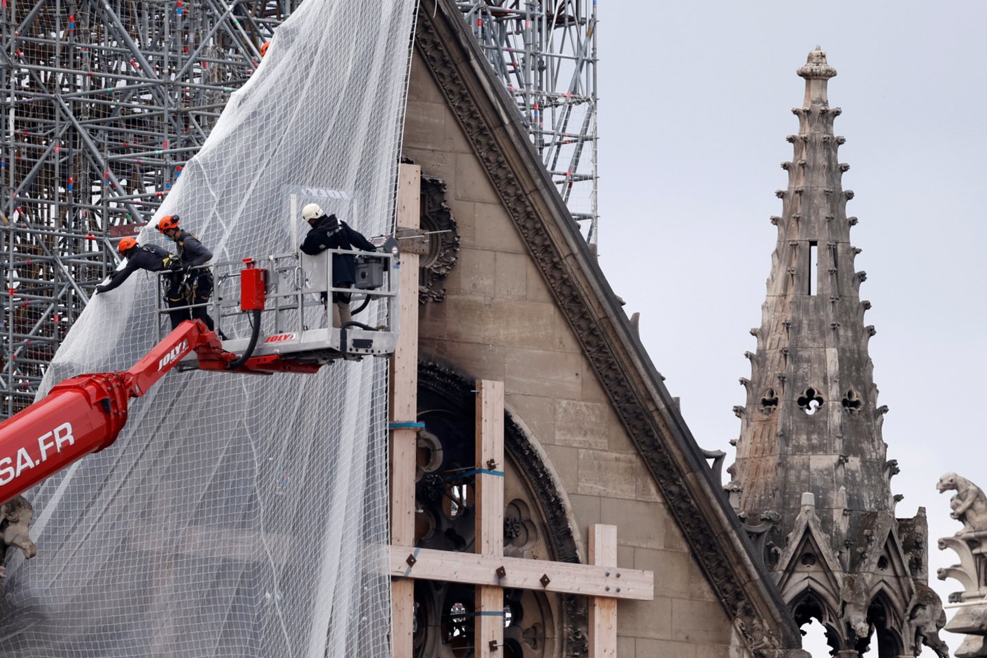  Paryžiuje darbininkai pradeda šalinti gaisro apgadintus pastolius Dievo Motinos katedroje.  <br> Reuters/Scanpix nuotr.