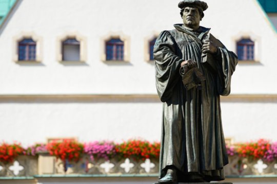 1517 m. augustinų vienuolis Martinas Lutheris, protestuodamas prieš Katalikų Bažnyčios propaguojamą indulgencijų prekybą, ant Vitenbergo bažnyčios durų Vokietijoje prikalė 95 tezes, kritikuojančias Katalikų Bažnyčią.<br>123rf