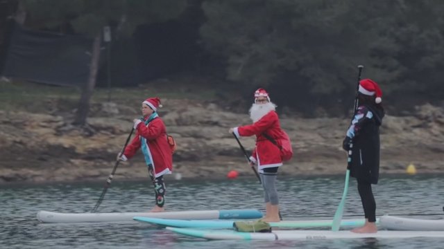 Kalėdų Seneliais apsirengę irklentininkai skrodė Adrijos jūrą dėl gražaus tikslo