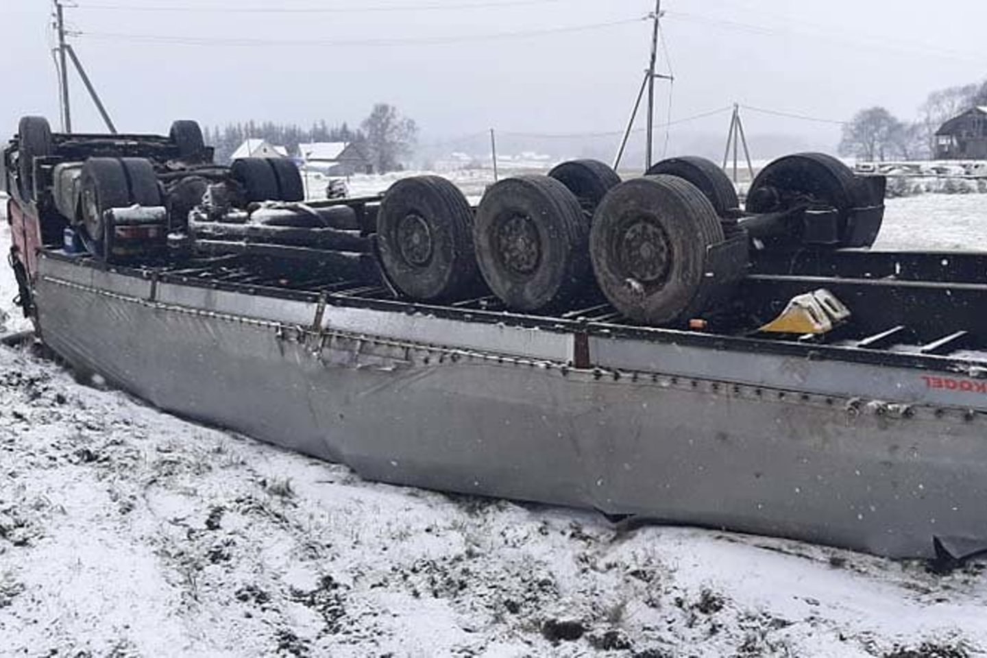 Nuo kelio nuslydęs sunkvežimis su priekaba apvirto.