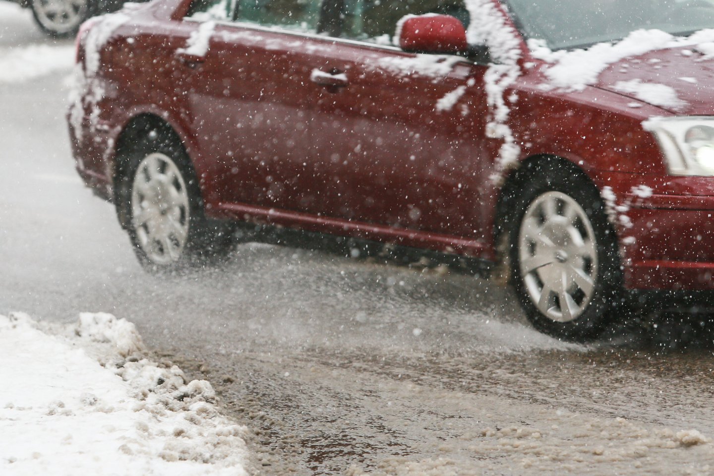Pavojais eismo saugumui žiemą grasina ne tik kelius, bet ir automobilius padengiantys sniego bei ledo sluoksniai.<br>G.Bitvinsko nuotr.