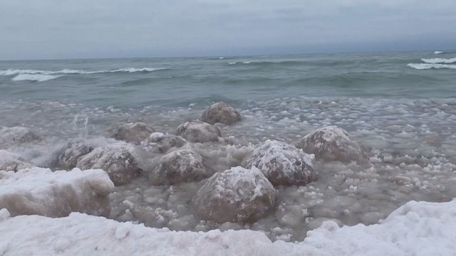 Prie ežero kranto žmonės aptiko netikėtą reginį: bangos suformavo milžiniškus ledo rutulius