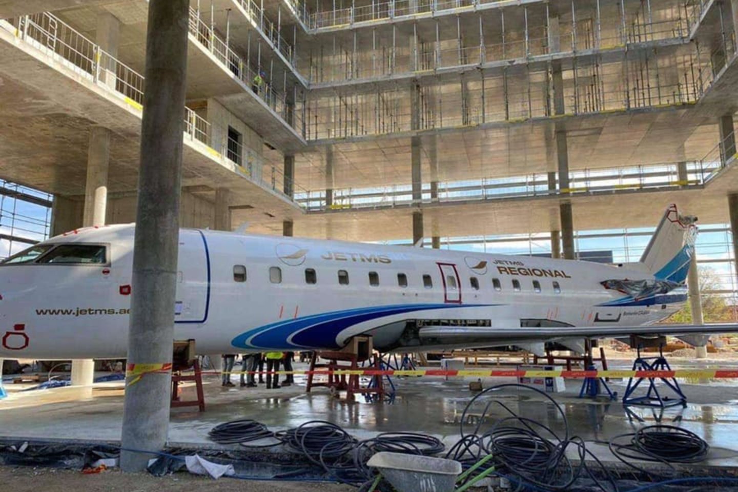 Užfiksuota ypatinga akimirka – realaus dydžio lėktuvas leidžiamas į pastato vidų.<br>G. Žiemelio nuotr.
