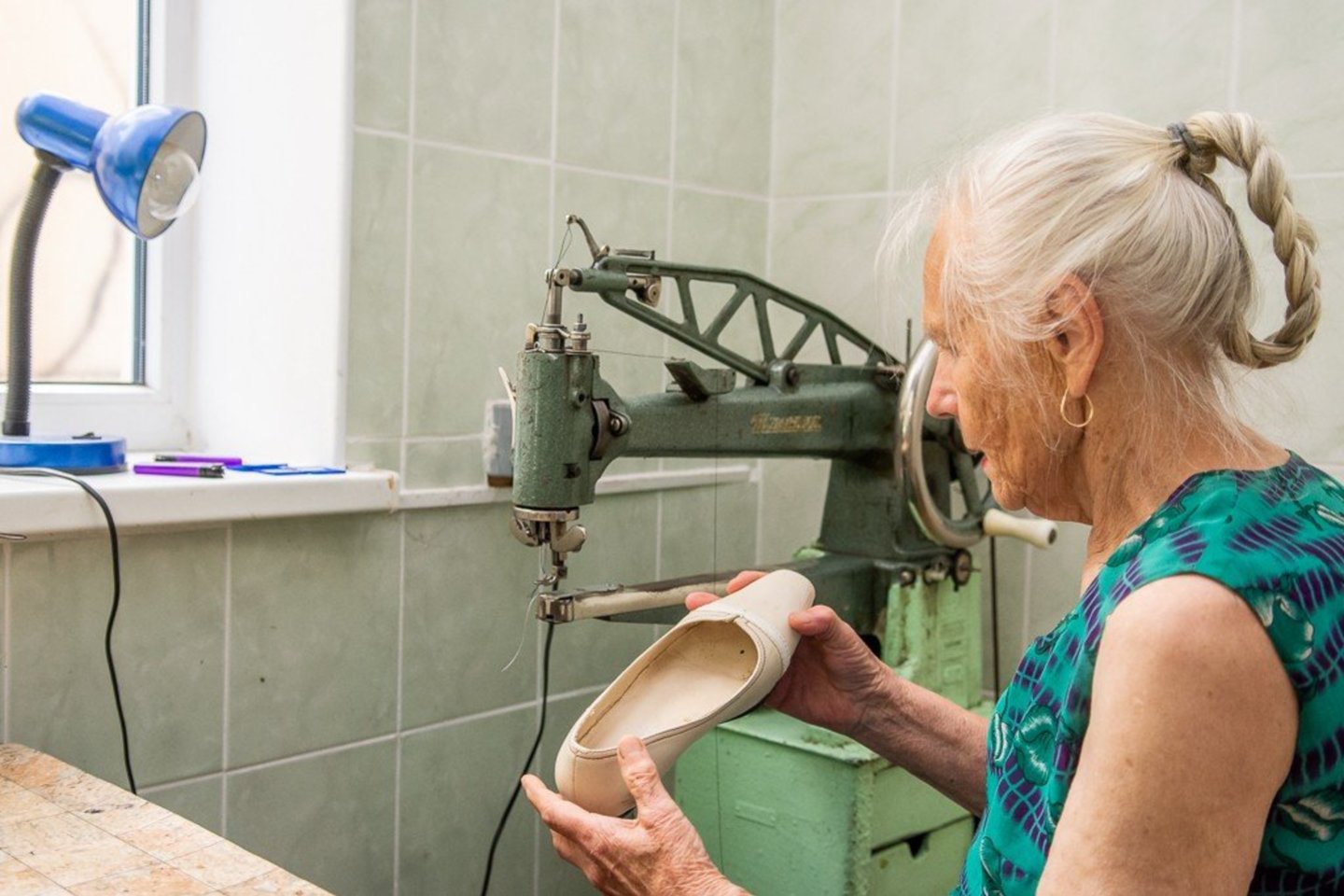85-erių E.A.Mačėnaitė sako, kad būti tik pensininke per daug nyku, todėl kiekvieną rytą senjorė skuba į darbą – į avalynės ir odos gaminių taisyklą „Klumpė“.<br> R.Ančerevičiaus/jp.lt nuotr.
