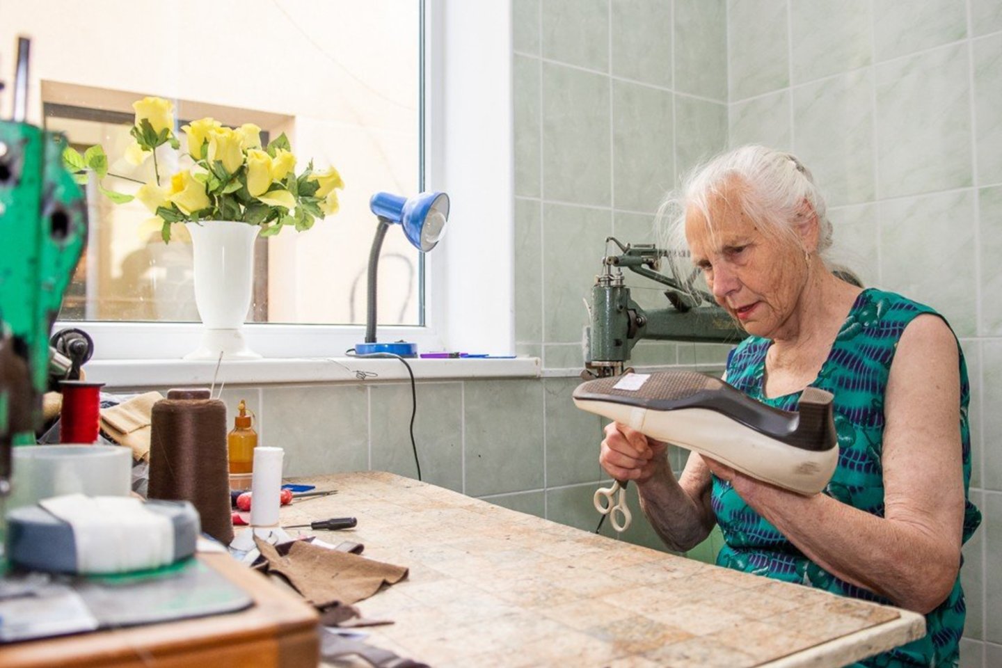 85-erių E.A.Mačėnaitė sako, kad būti tik pensininke per daug nyku, todėl kiekvieną rytą senjorė skuba į darbą – į avalynės ir odos gaminių taisyklą „Klumpė“.<br> R.Ančerevičiaus/jp.lt nuotr.
