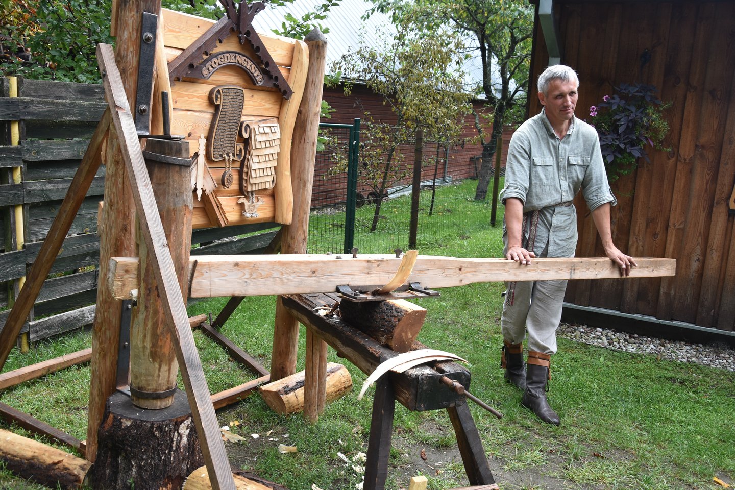 Tradicinių amatų meistras G.Čekauskas pamoko, kaip skaldyti skiedras stogams dengti.<br>A.Srėbalienės nuotr.