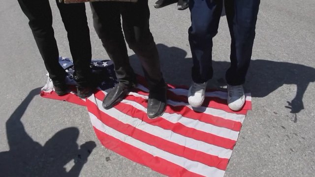 Minios žmonių protestavo prieš JAV deportuotus migrantus iš Haičio: kai kurie trypė Amerikos vėliavą 