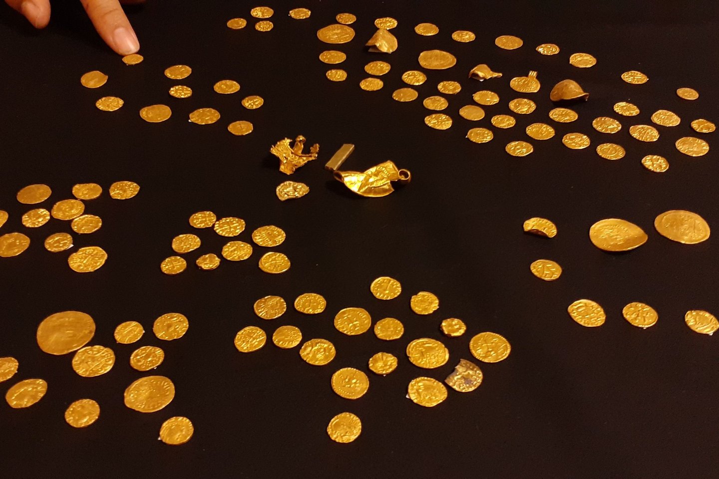  Vakarų Norfolke metalo detektoriaus savininko aptiko didžiausią kada nors surastą anglosaksų lobį – 131 monetą ir keturis aukso dirbinius.<br> Britų muziejaus nuotr.