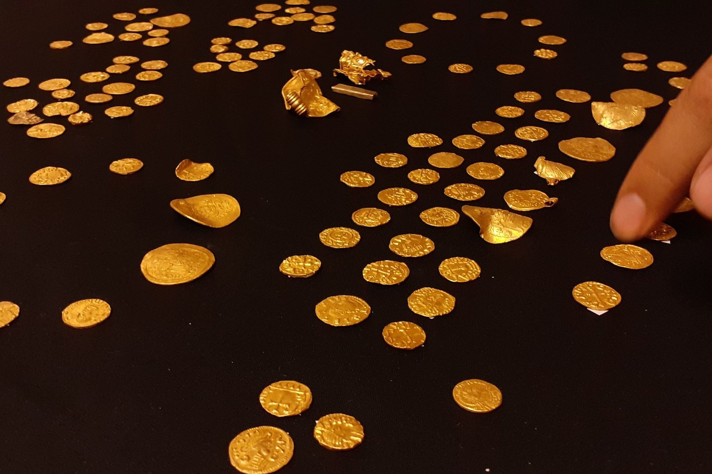  Vakarų Norfolke metalo detektoriaus savininko aptiko didžiausią kada nors surastą anglosaksų lobį – 131 monetą ir keturis aukso dirbinius.<br> Britų muziejaus nuotr.