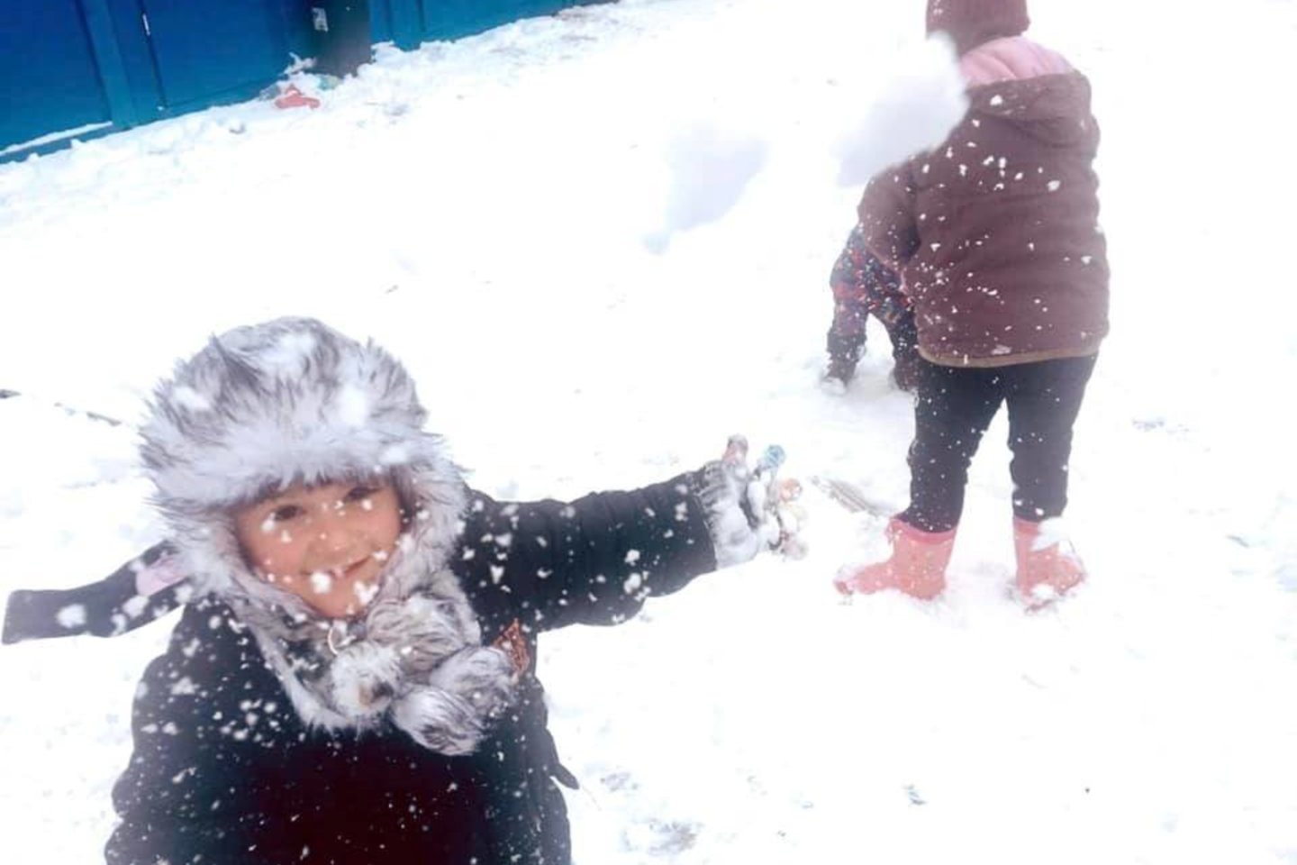 Pirmasis sniegas Medininkuose įrengtuose moduliniuose nameliuose šiuo metu gyvenančius migrantus itin sužavėjo – laiką lauke leidžia tiek vaikai, tiek jų motinos.<br>„Raudonojo kryžiaus“ nuotr.