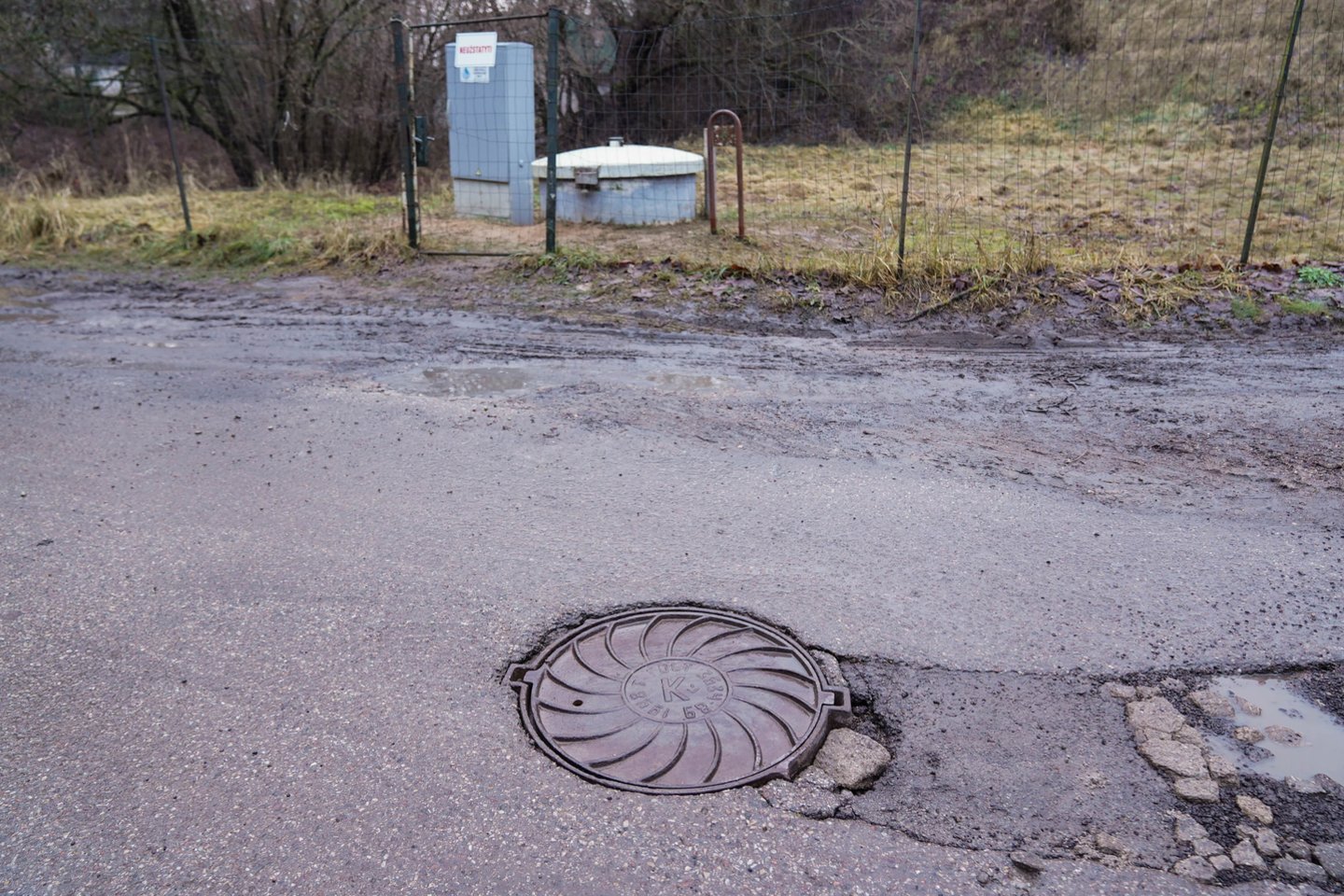 Vanduo į kiemus veržiasi iš netoliese esančio buitinių tinklų kanalizacijos šulinio.<br>G.Bitvinsko nuotr.