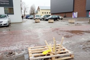 Miesto centre atsivėrė duobė, į kurią sukrito trinkelės: pavojingą vietą medinėmis paletėmis uždengė vairuotojai